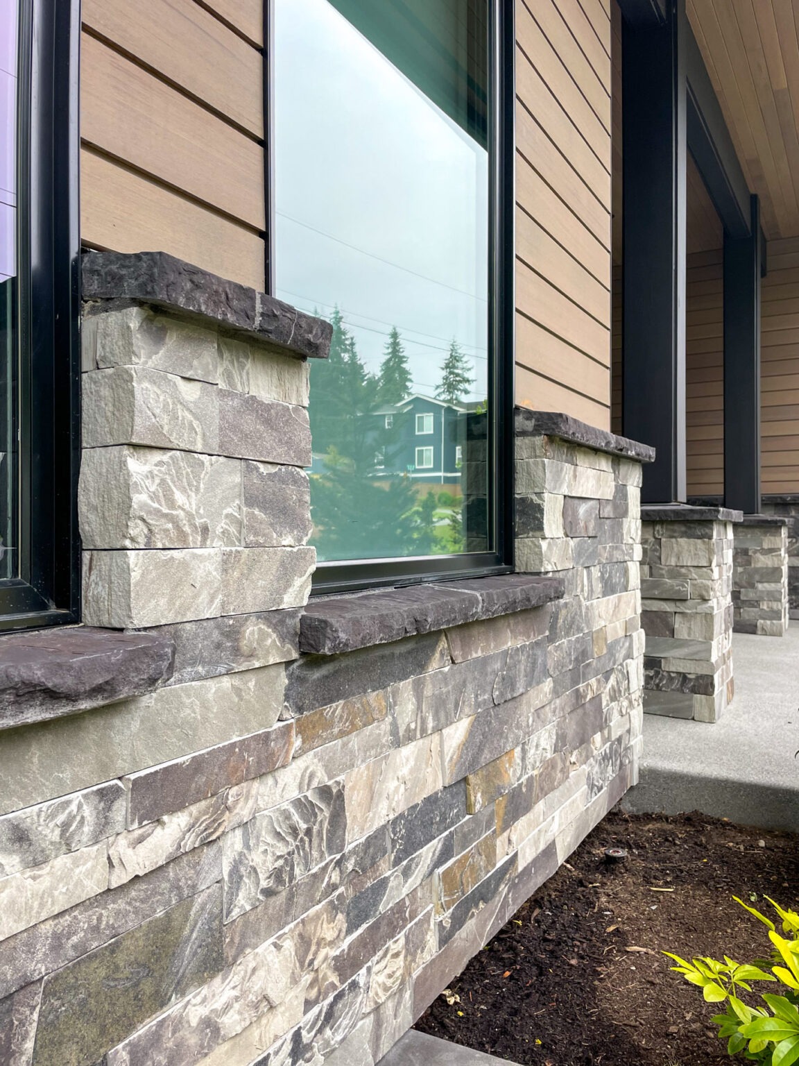 Gray stone veneer base below windows on the Black Horse project